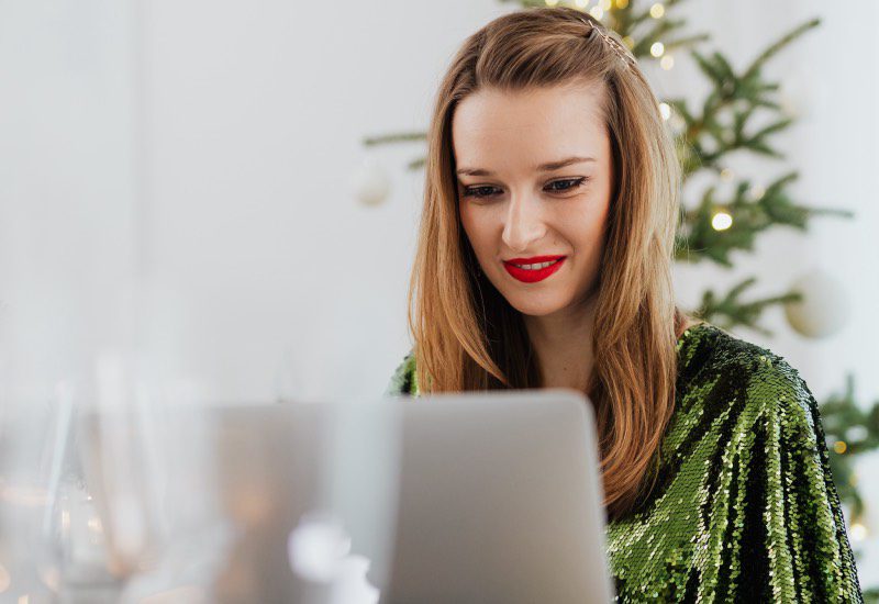 woman on computer in a holiday outfit
